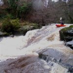 Photo of the Colligan river in County Waterford Ireland. Pictures of Irish whitewater kayaking and canoeing. kevin atop the salmon leap in big water. Photo by Michael Flynn